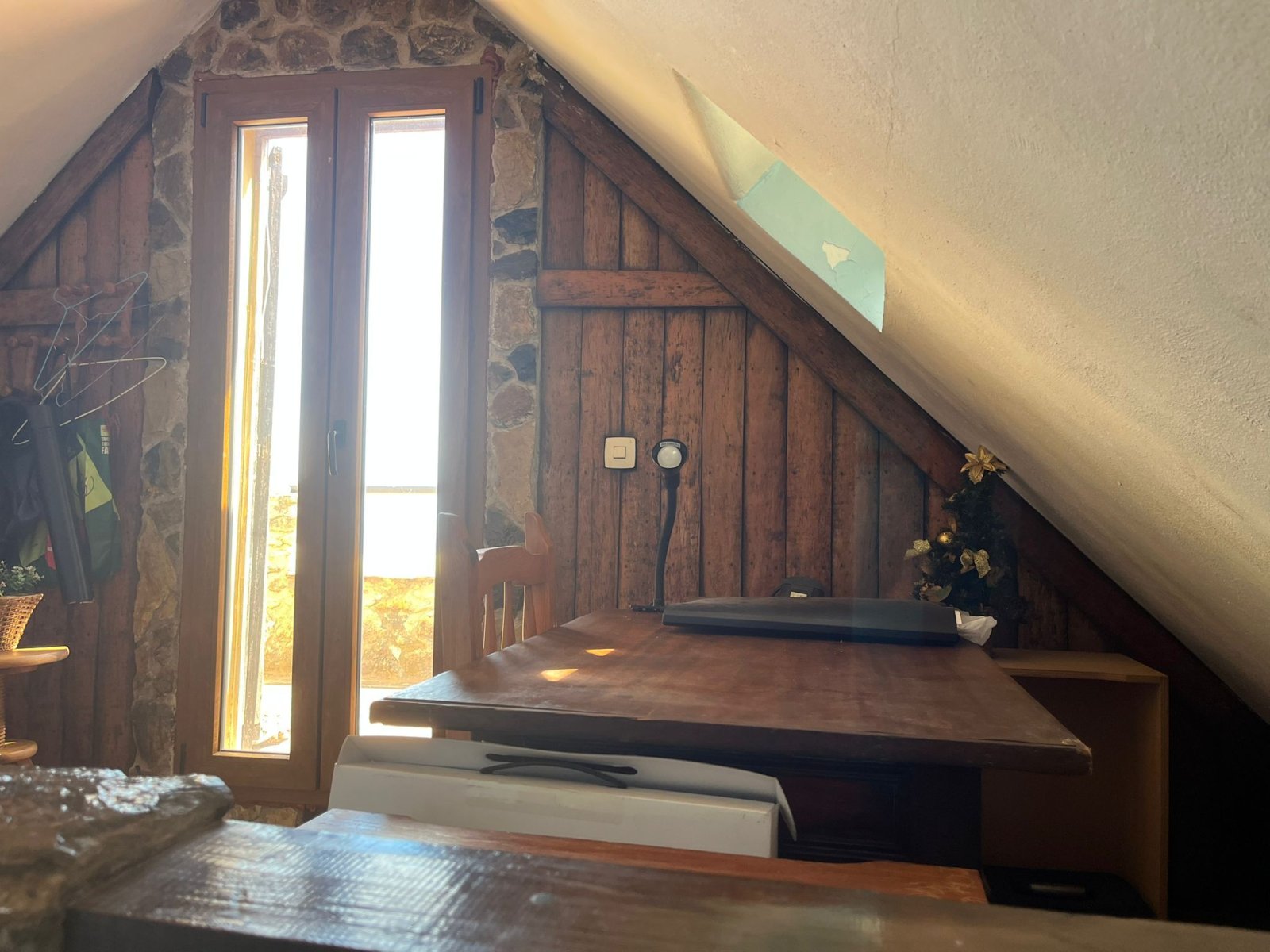 Dachgeschoss-Schlafzimmer mit französischen Balkontüren, Natursteinwänden und rustikalen Dachbalken – authentischer Charakter mit Ausblick Dachgeschoss-Schlafzimmer mit französischen Balkontüren, Natursteinwänden und rustikalen Dachbalken – authentischer Charakter mit Ausblick
