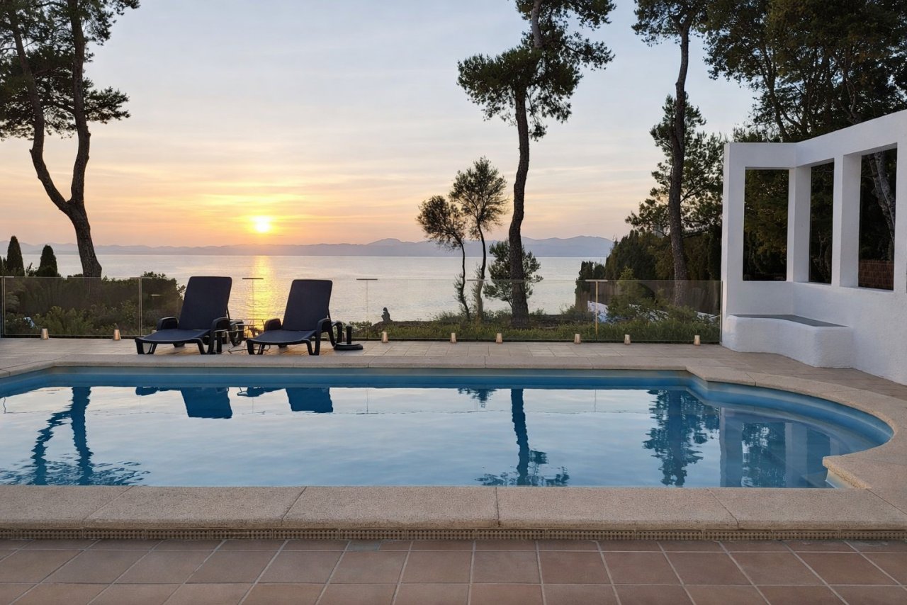 Poolanlage mit Sonnenuntergang über dem Meer und modernem Poolhaus Poolanlage mit Sonnenuntergang über dem Meer und modernem Poolhaus