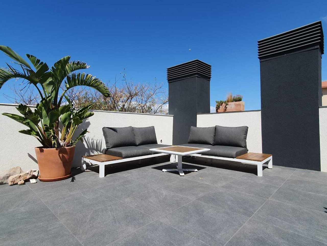 Exklusive Dachterrasse mit modernem Kaminbereich und hochwertiger Natursteinbelägen