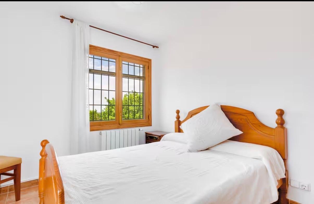 Helles Schlafzimmer mit Holzfenstern und effizienter Raumnutzung Helles Schlafzimmer mit Holzfenstern und effizienter Raumnutzung