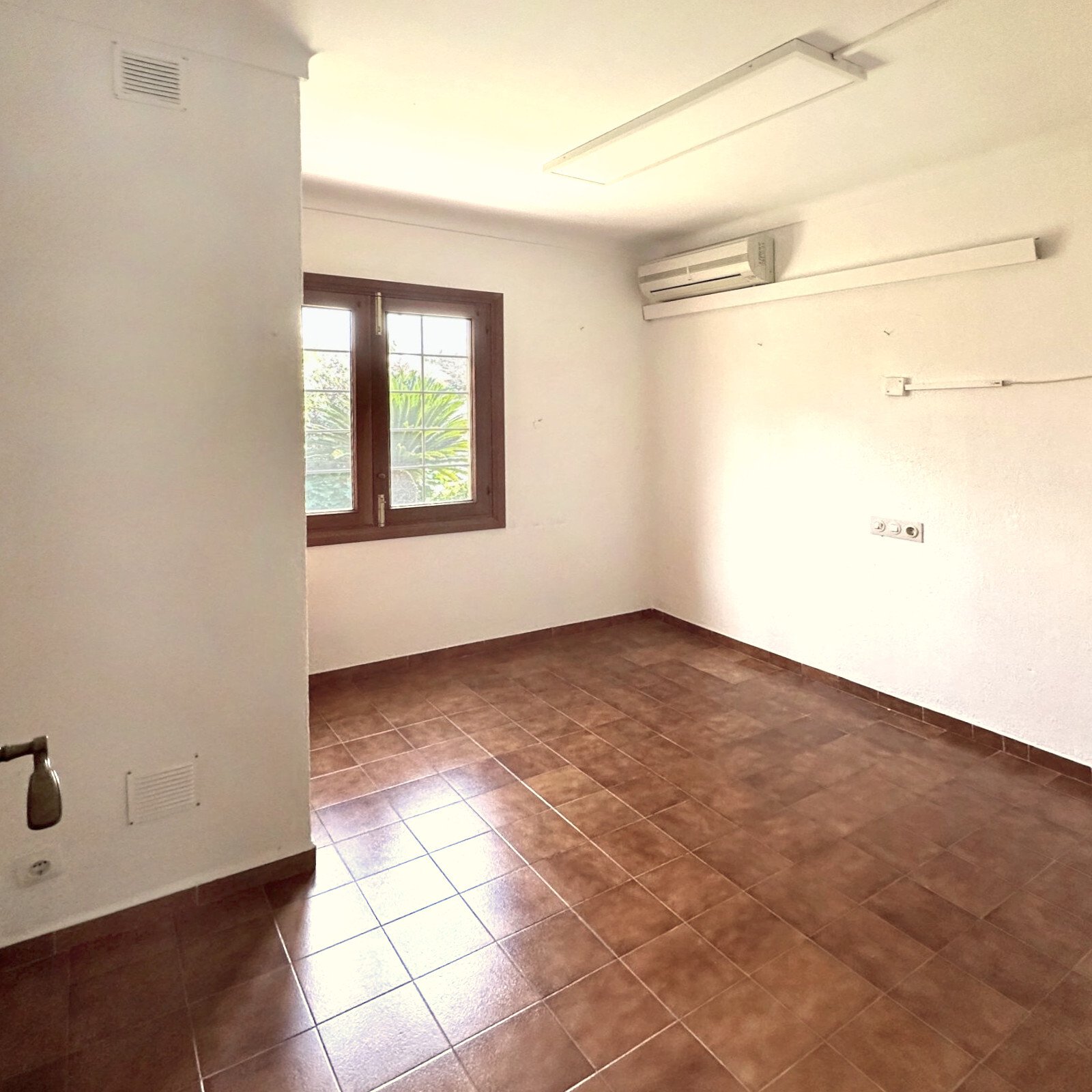 Helles Zimmer mit Klimaanlage, Fensterfront und praktischer Grundrissgestaltung