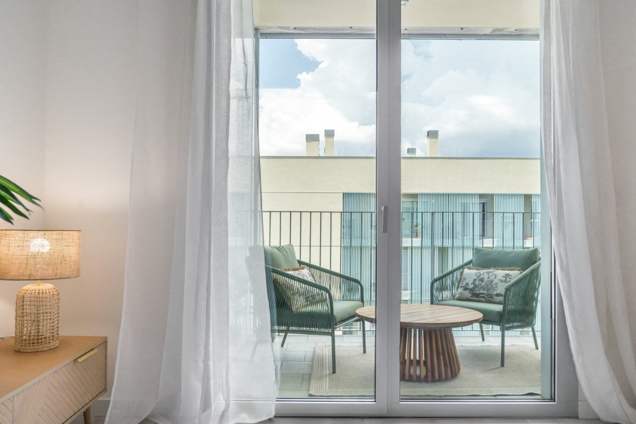 Moderner Balkon mit raumhohen Glasschiebetüren und freiem Himmelblick