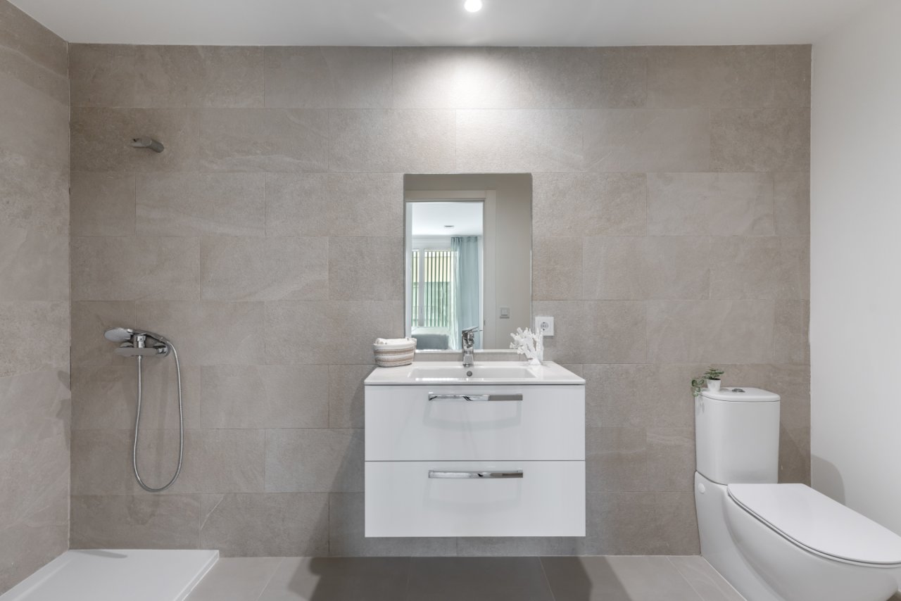 Modernes Badezimmer mit bodengleicher Dusche und großflächigem Spiegel