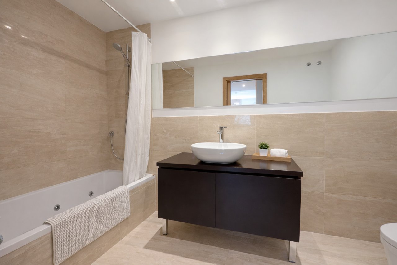 Modernes Badezimmer mit Wanne, Dusche und großflächigen Spiegelelementen Modernes Badezimmer mit Wanne, Dusche und großflächigen Spiegelelementen