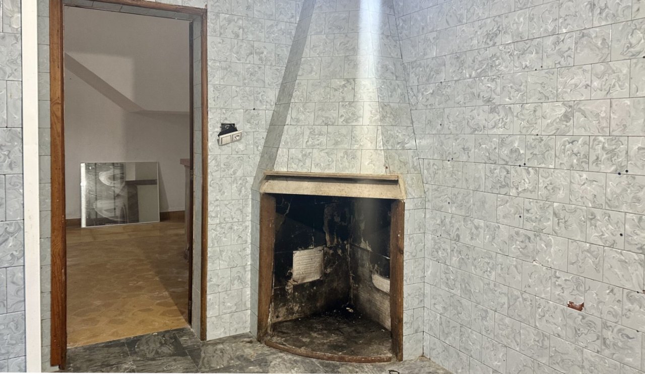 Kaminzimmer mit authentischem Kachelofen und großflächiger Wandgestaltung