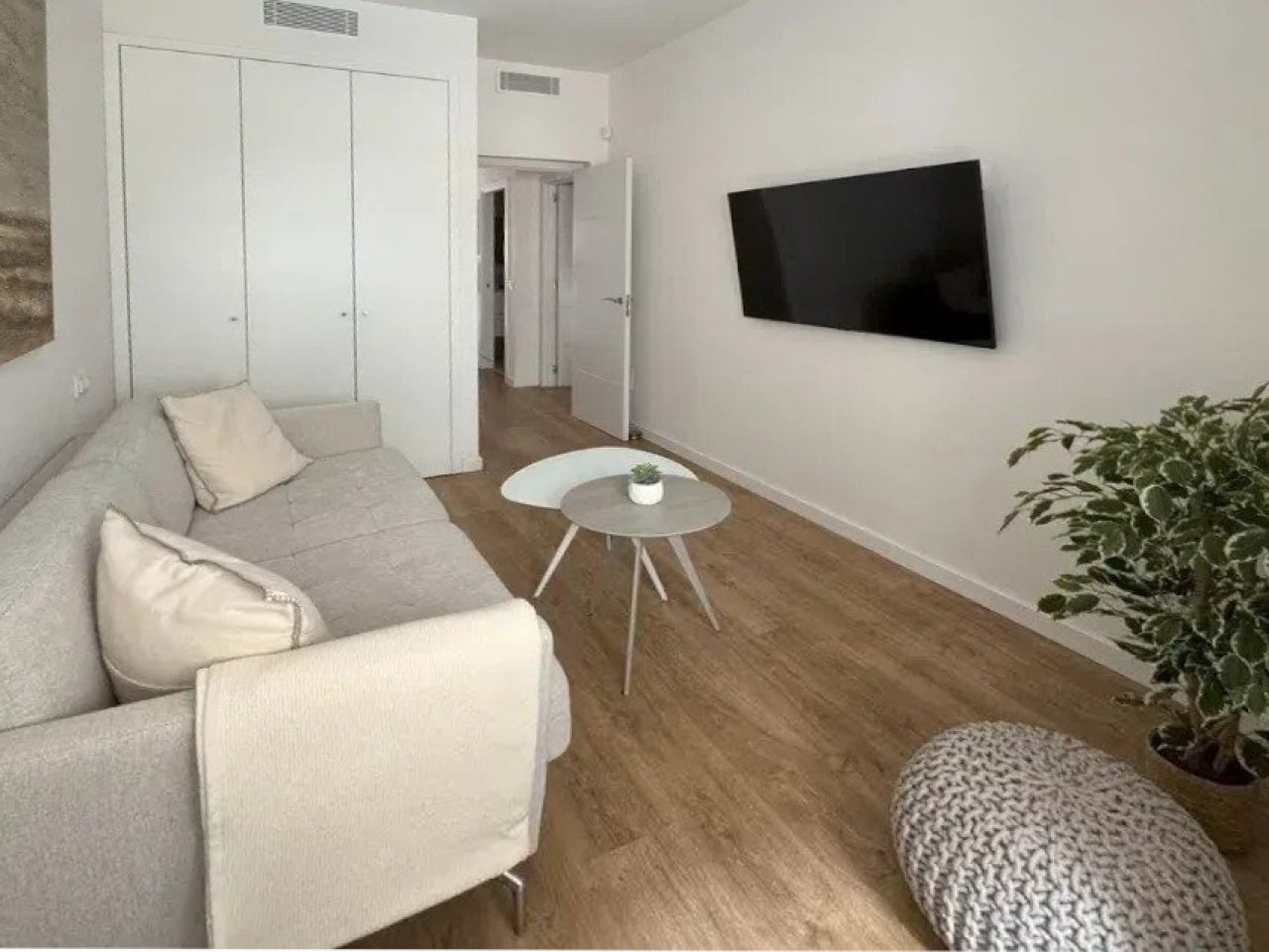 Wohnzimmer mit offener Raumaufteilung und Zugang zum Schlafbereich