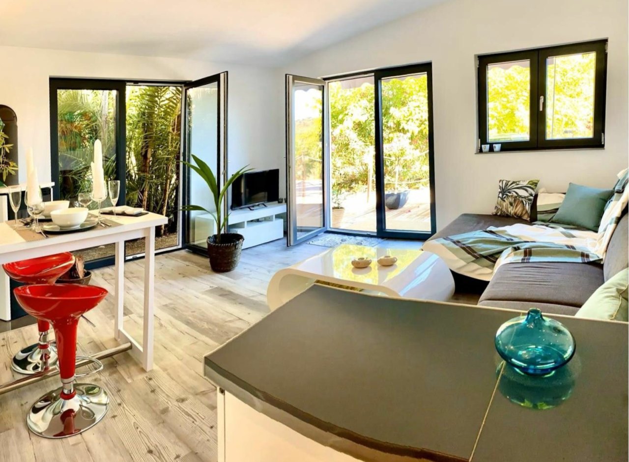 Licht durchfluteter Wohnbereich mit großflächigen Glasschiebetüren und Zugang zur Terrasse Licht durchfluteter Wohnbereich mit großflächigen Glasschiebetüren und Zugang zur Terrasse