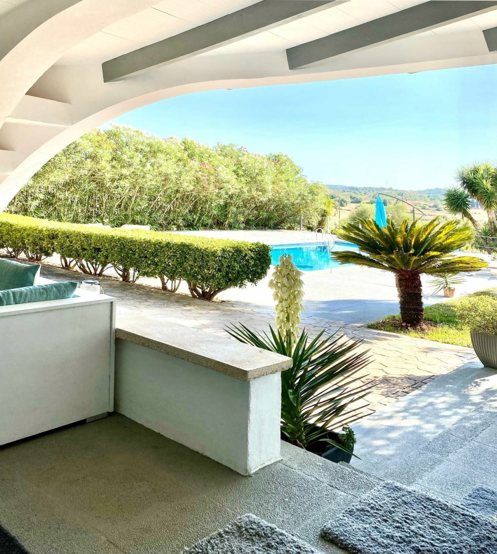 Überdachte Lounge-Terrasse mit eleganter Bogenkonstruktion und freiem Panoramablick auf Pool und Landschaft Überdachte Lounge-Terrasse mit eleganter Bogenkonstruktion und freiem Panoramablick auf Pool und Landschaft