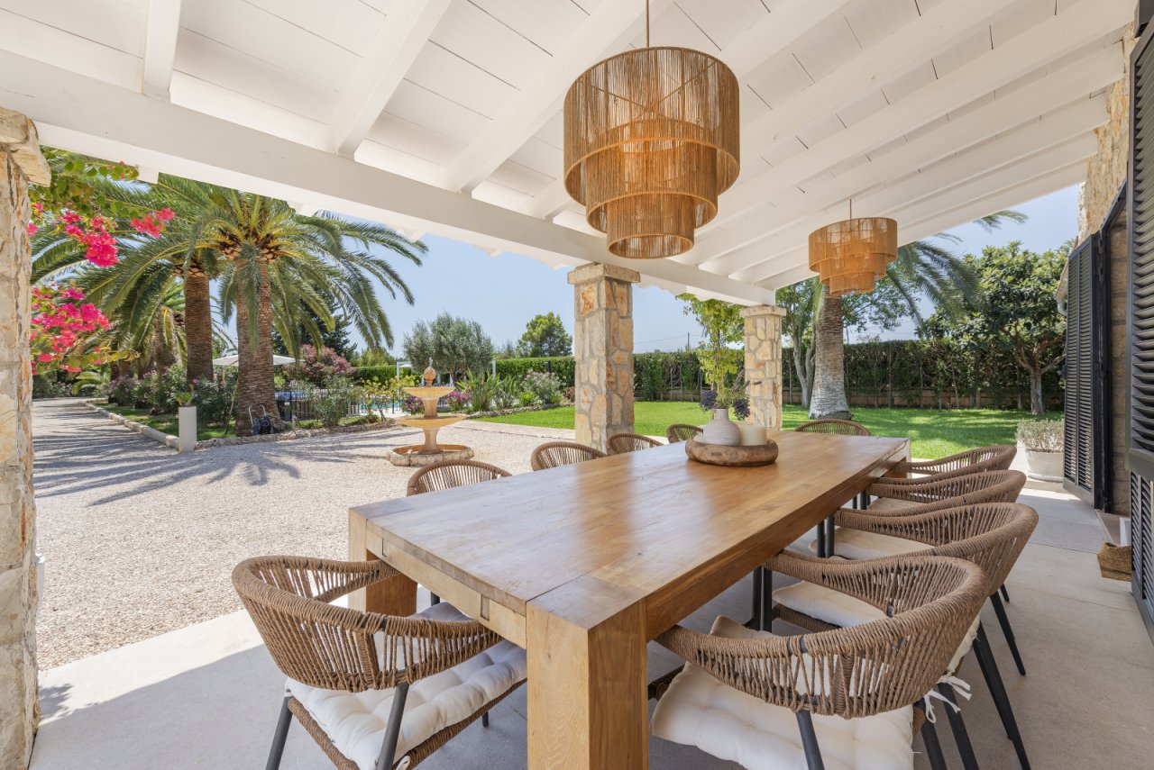 Überdachter Essbereich mit eleganter Säulenarchitektur und nahtlosem Übergang zum Garten Überdachter Essbereich mit eleganter Säulenarchitektur und nahtlosem Übergang zum Garten