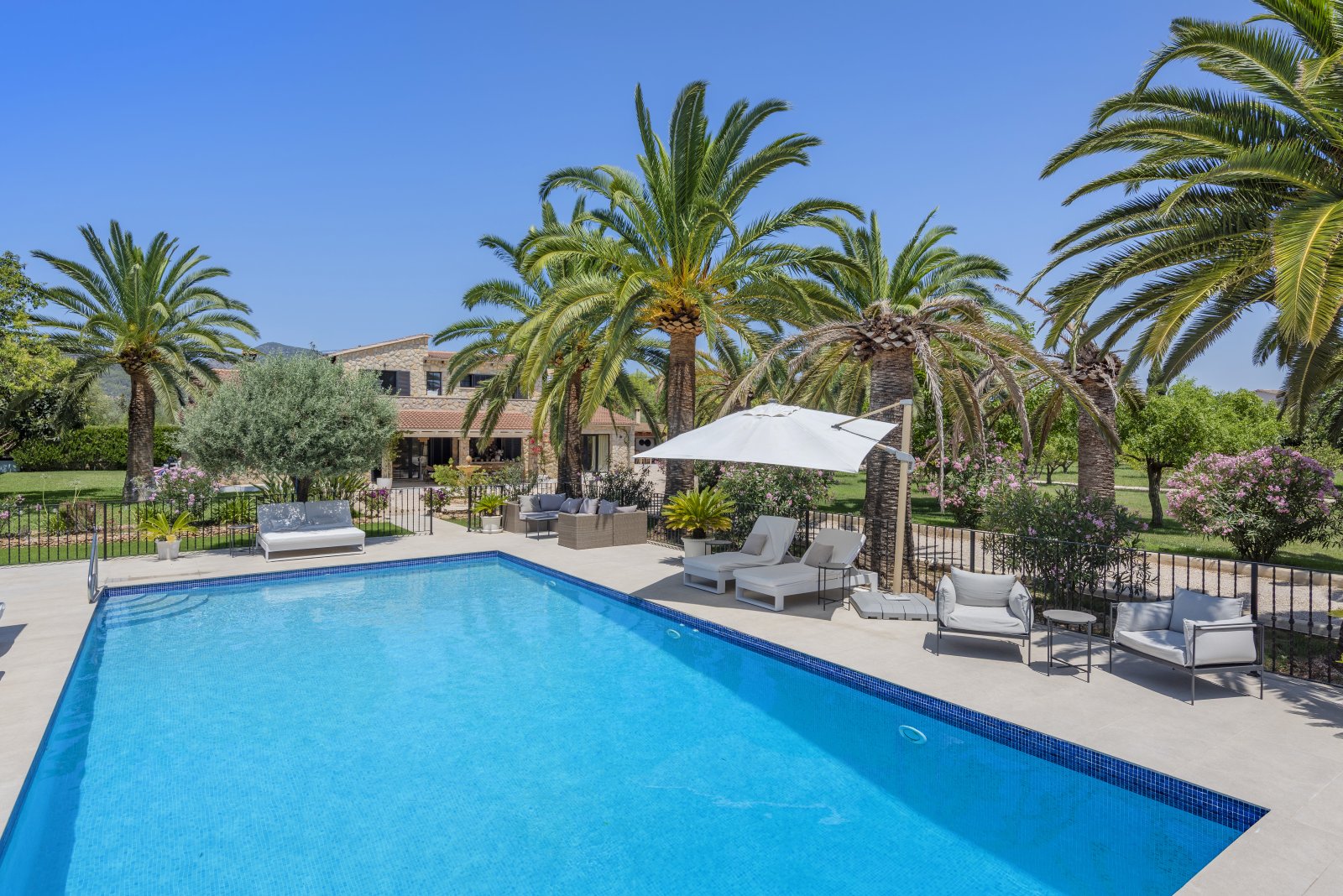 Luxuriöser Poolbereich mit großflächiger Terrasse und Sonnenschutz Luxuriöser Poolbereich mit großflächiger Terrasse und Sonnenschutz