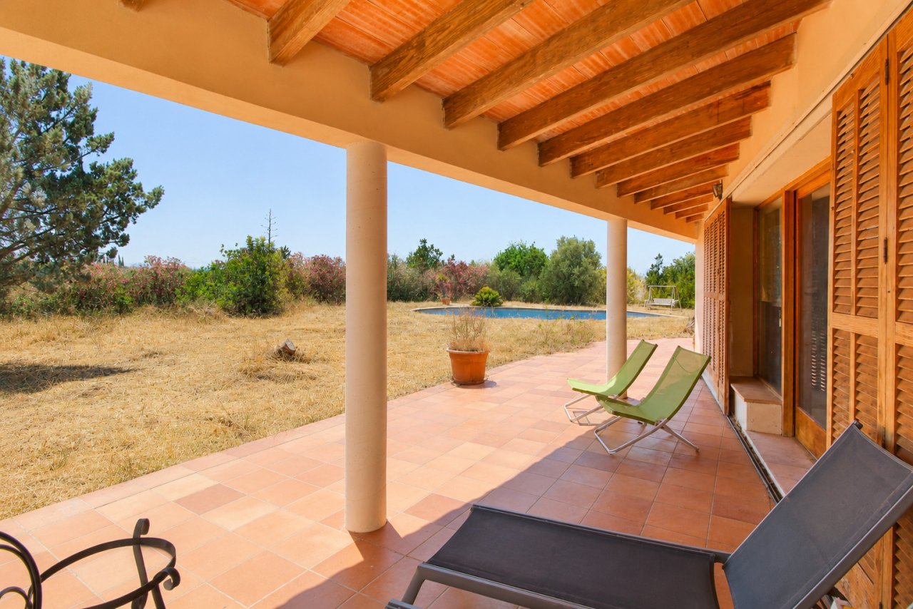 Überdachte Terrasse mit tragenden Holzbalken und direktem Poolblick Überdachte Terrasse mit tragenden Holzbalken und direktem Poolblick