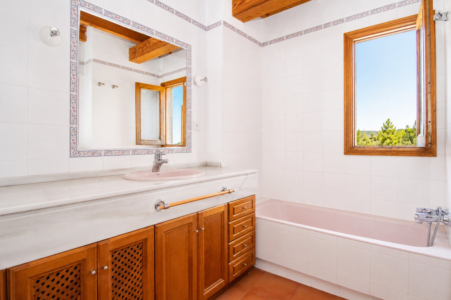 Badezimmer mit breiter Waschtischanlage und Fensterblick ins Grüne Badezimmer mit breiter Waschtischanlage und Fensterblick ins Grüne