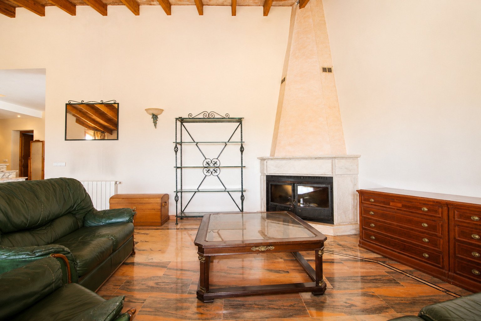 Wohnzimmer mit imposantem Kamin und Holzdeckenbalken Wohnzimmer mit imposantem Kamin und Holzdeckenbalken