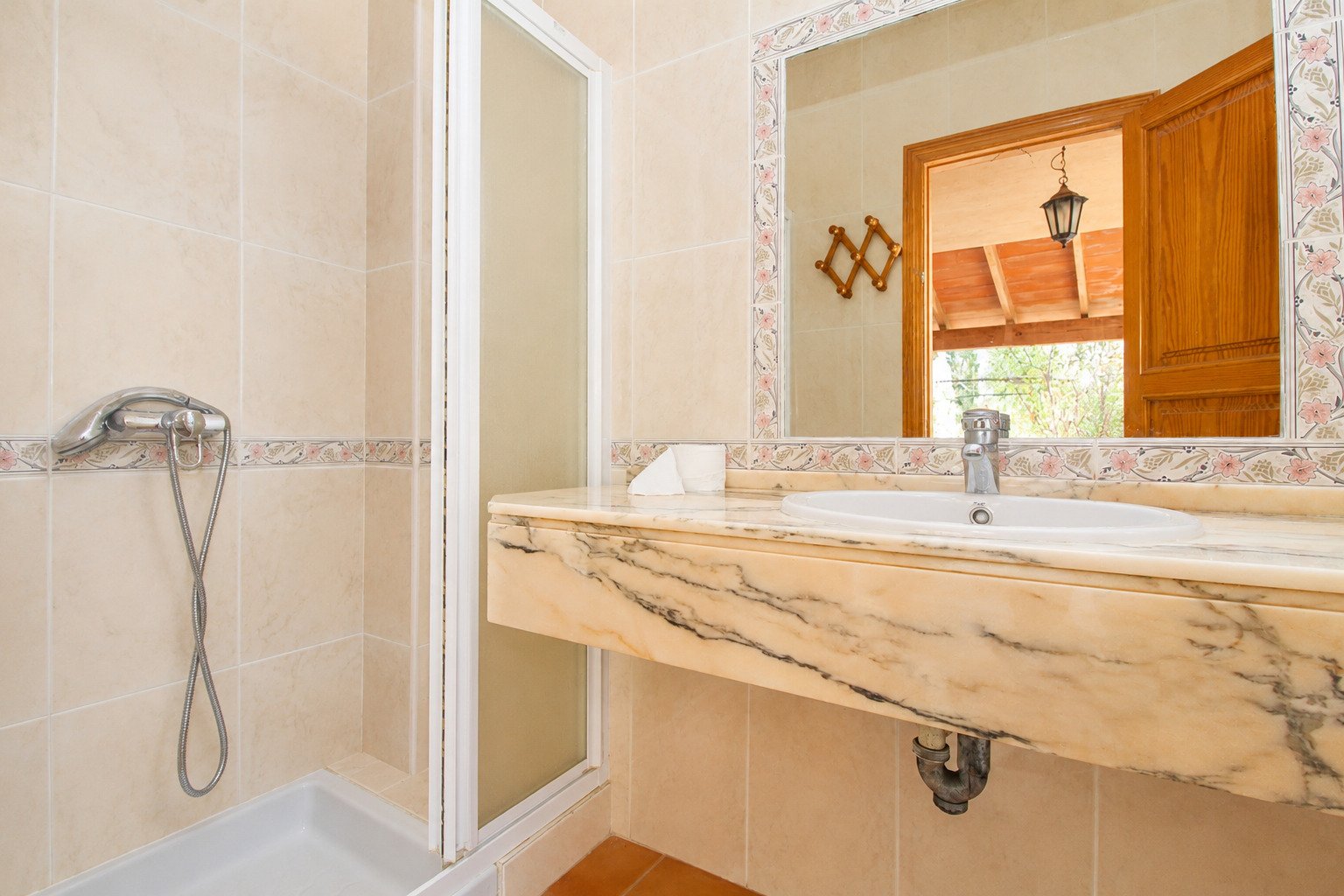 Elegantes Badezimmer mit Marmor-Waschtisch und ebenerdiger Dusche Elegantes Badezimmer mit Marmor-Waschtisch und ebenerdiger Dusche