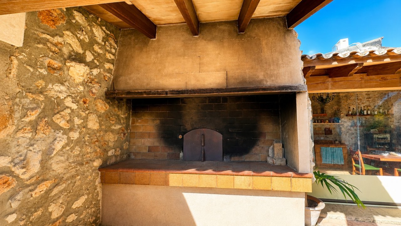 Authentische Außenküche mit massivem Steinbackofen und rustikaler Holzbalkenüberdachung Authentische Außenküche mit massivem Steinbackofen und rustikaler Holzbalkenüberdachung