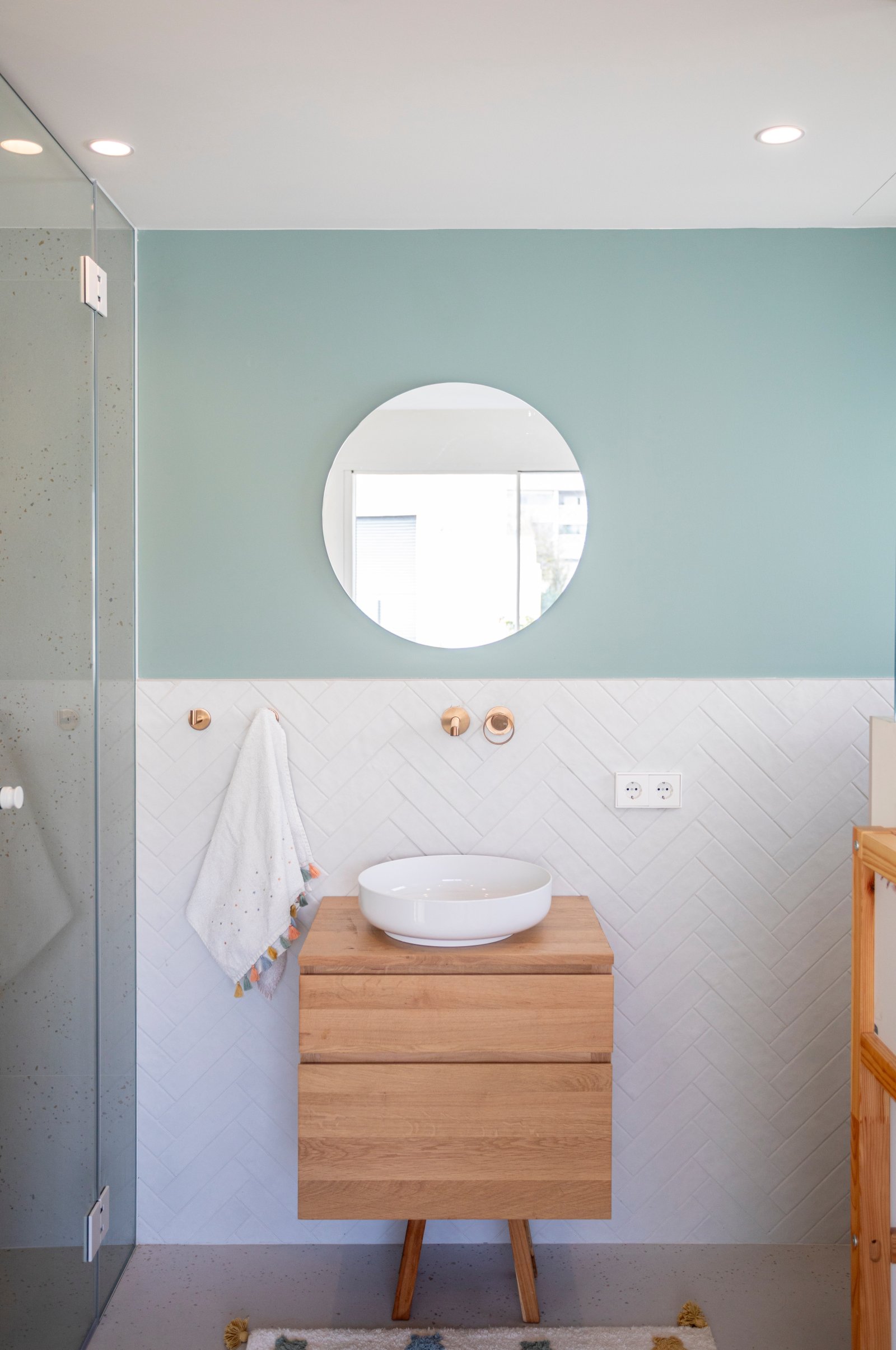 Elegantes Badezimmer mit raumhoher Fliesengestaltung und modernem Waschtischbereich