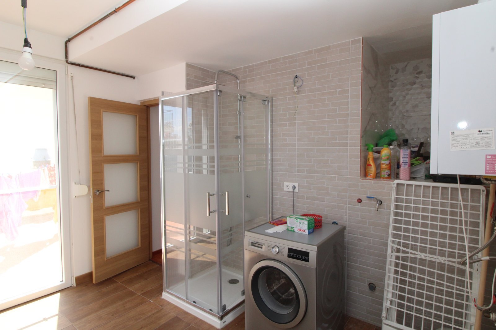 Modernes Badezimmer mit bodengleicher Dusche und praktischer Waschmaschinenintegration Modernes Badezimmer mit bodengleicher Dusche und praktischer Waschmaschinenintegration