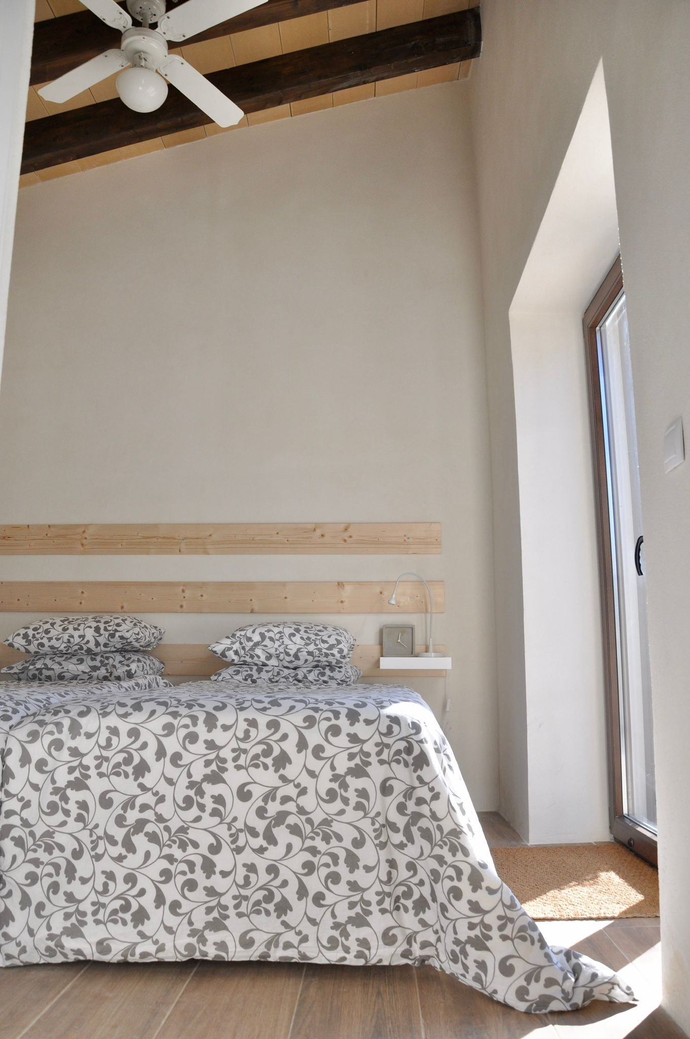 Helles Schlafzimmer mit Sichtbalkendecke und direktem Zugang zum Außenbereich Helles Schlafzimmer mit Sichtbalkendecke und direktem Zugang zum Außenbereich