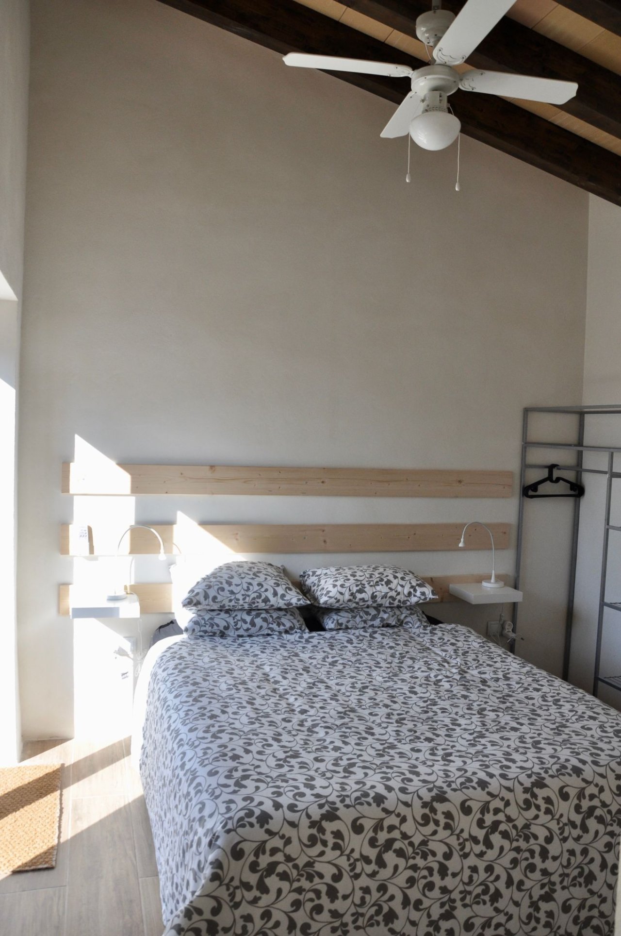 Helles Schlafzimmer mit Dachschräge, Deckenventilator und integrierter Nachttischanlage Helles Schlafzimmer mit Dachschräge, Deckenventilator und integrierter Nachttischanlage