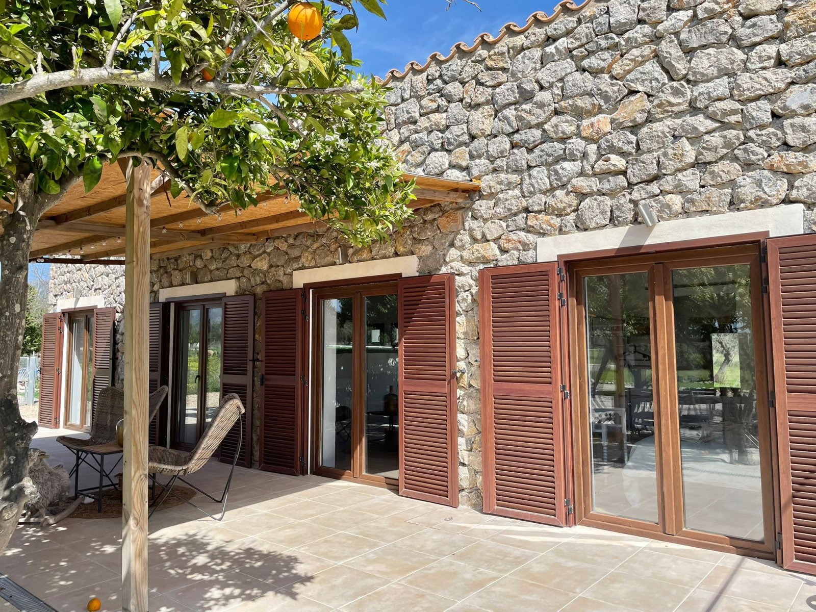 Authentische Natursteinfassade mit direktem Terrassenzugang und Pergola-Überdachung Authentische Natursteinfassade mit direktem Terrassenzugang und Pergola-Überdachung