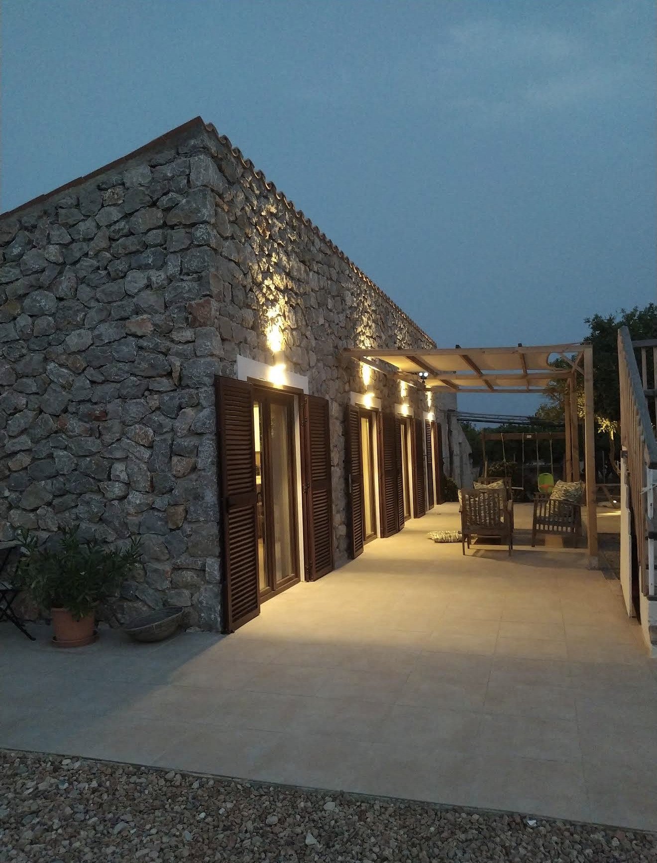 Elegante Natursteinfassade mit großzügiger Terrassenanlage und Pergola Elegante Natursteinfassade mit großzügiger Terrassenanlage und Pergola