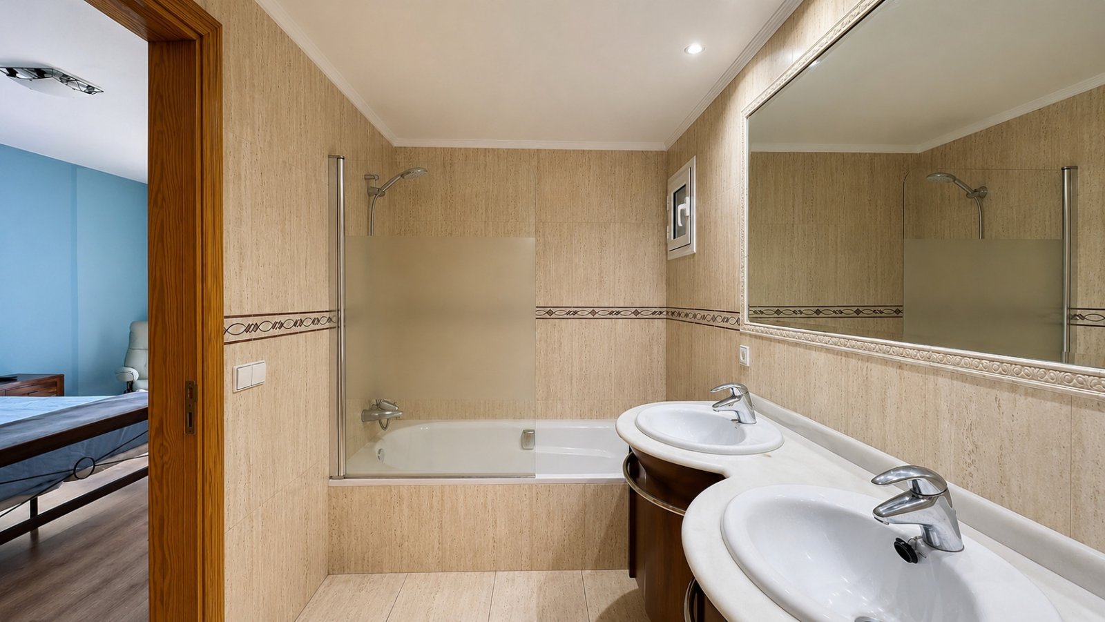 Luxuriöses Badezimmer mit Doppelwaschtisch, begehbarer Dusche und großflächigem Spiegel