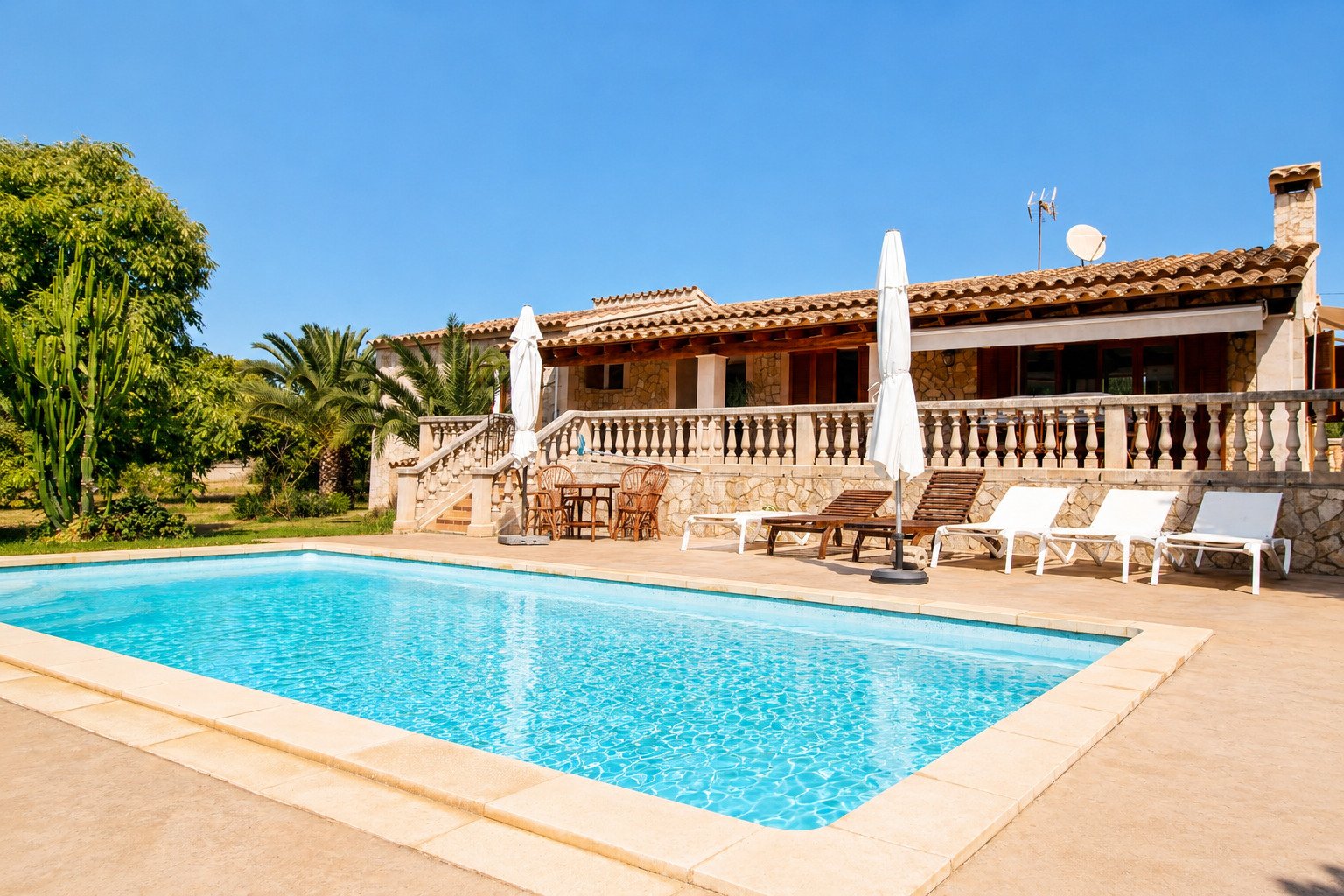 Poolbereich mit sonniger Terrasse und eleganter Balustrade