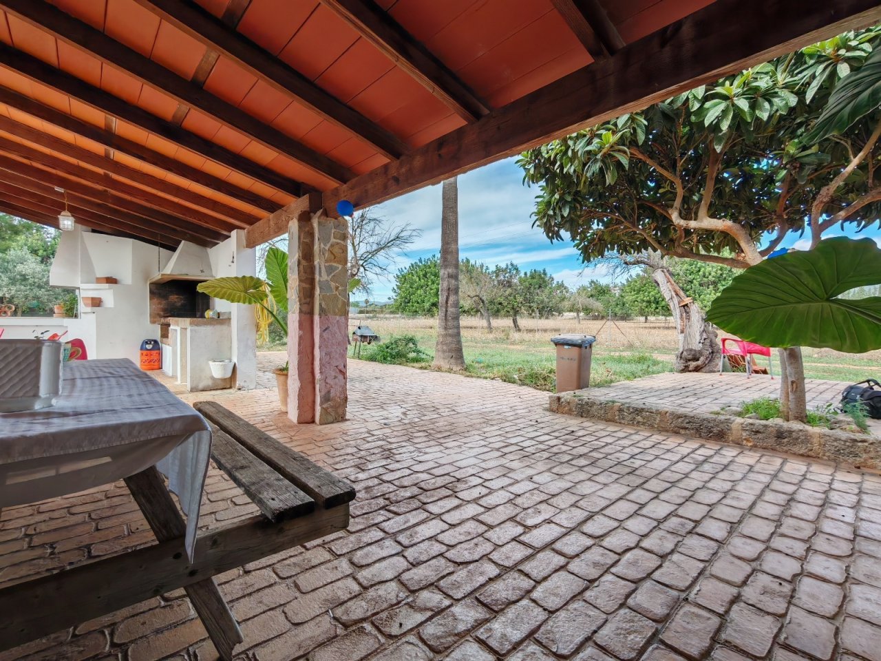 Überdachte Terrasse mit rustikalem Holzgebälk und freiem Blick auf die Landschaft