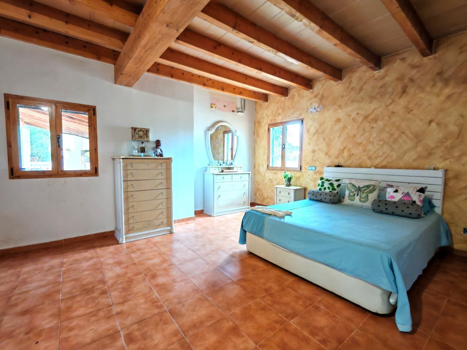 Schlafzimmer mit Holzdeckengebälk und reichlich Platzangebot für individuelles Wohnen