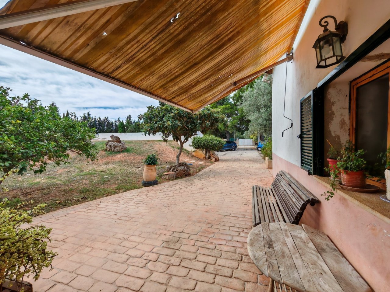 Überdachte Terrasse mit großzügiger Freifläche und Ausblick ins Grüne