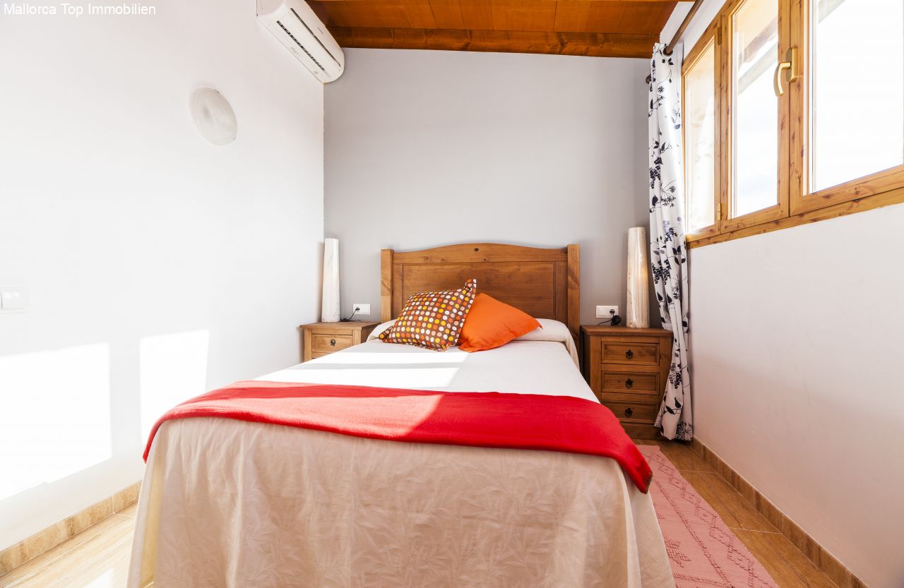 Helles Schlafzimmer mit Holzdecke und klimatisierter Ausstattung