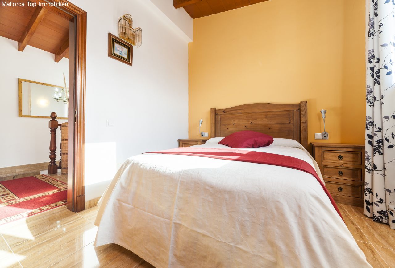 Komfortables Schlafzimmer mit Ankleidebereich und begehbarem Ankleidezimmer