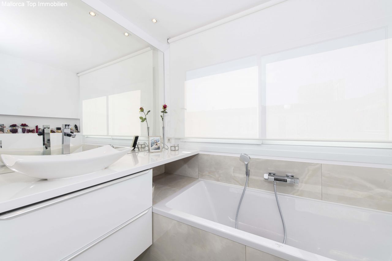Modernes Badezimmer mit freistehender Wanne und großflächiger Spiegelfront