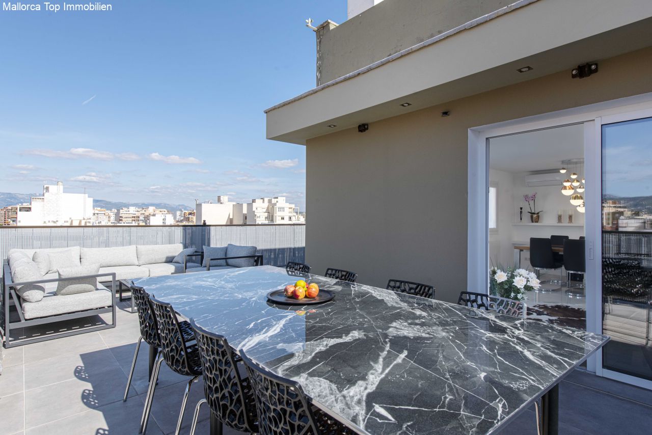 Dachterrasse mit Marmor-Esstisch und freiem Blick über die Stadt