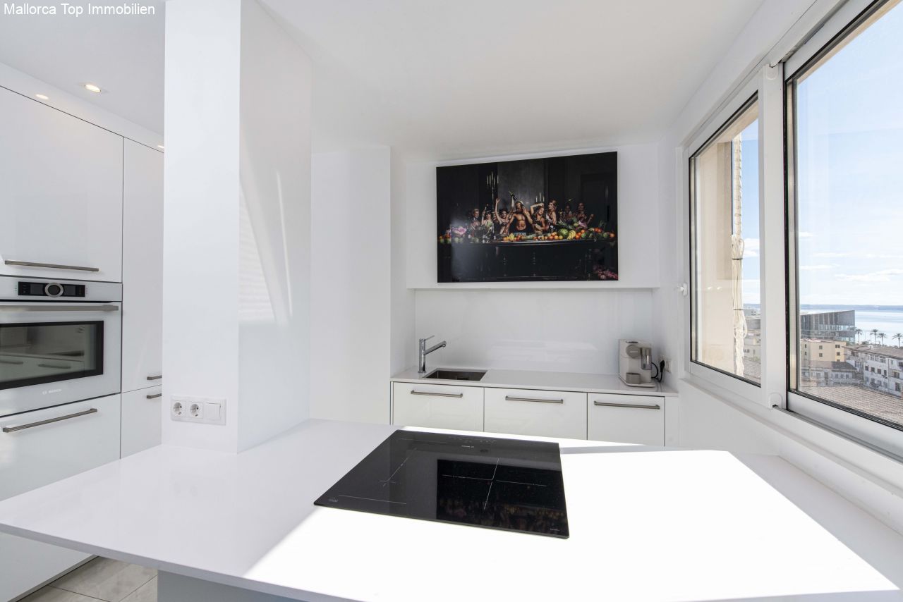 Moderne Küche mit hochwertigen Einbaugeräten und Panoramafenstern zum Meerblick