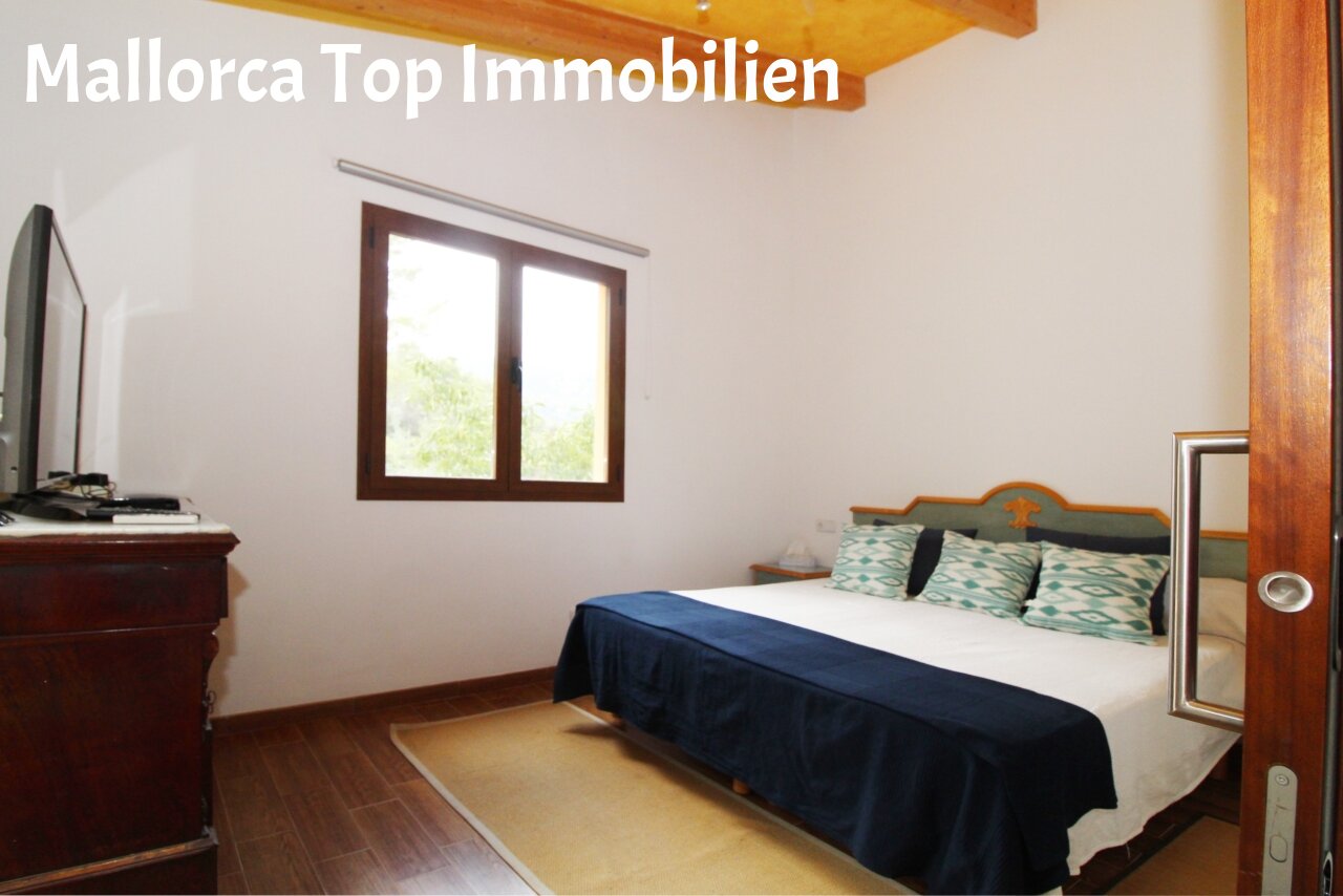 Helles Schlafzimmer mit Dachbalken und großflächigem Fenster für optimale Helligkeit