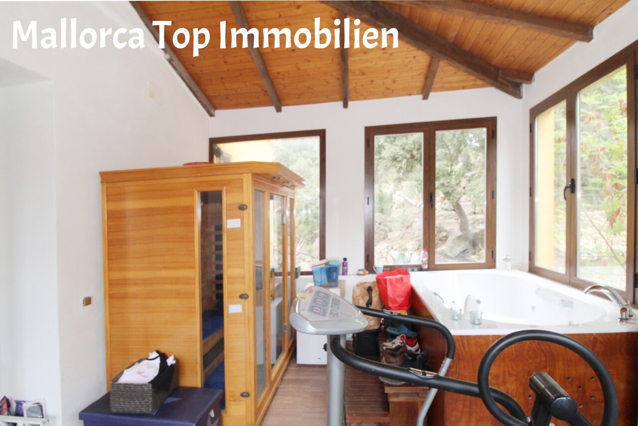 Wellness-Oase mit Sauna und freistehender Badewanne unter Holzdecke