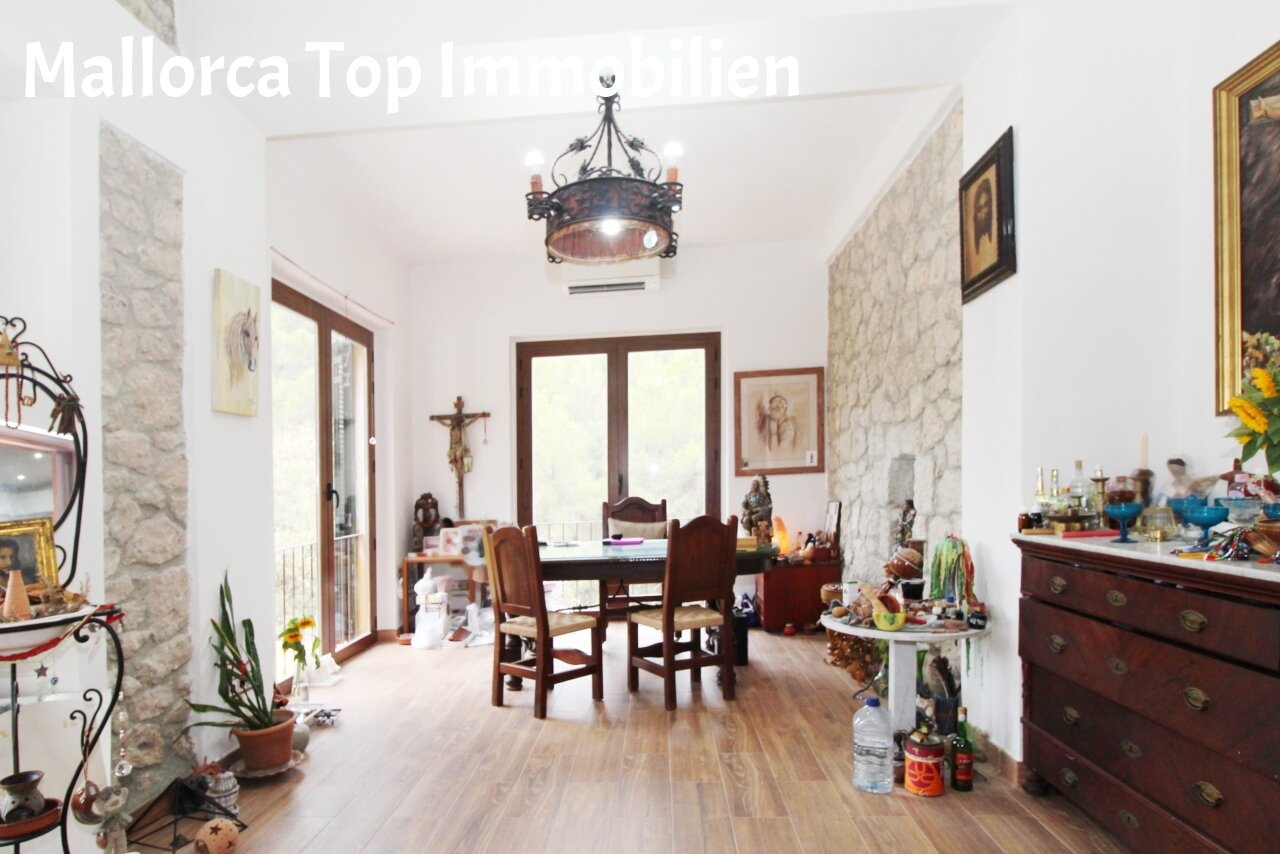 Helles Wohnzimmer mit direktem Zugang zur Terrasse und Natursteinwänden
