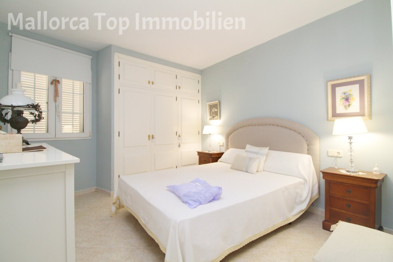 Komfortables Schlafzimmer mit raumhoher Schrankanlage und praktischem Ankleidebereich