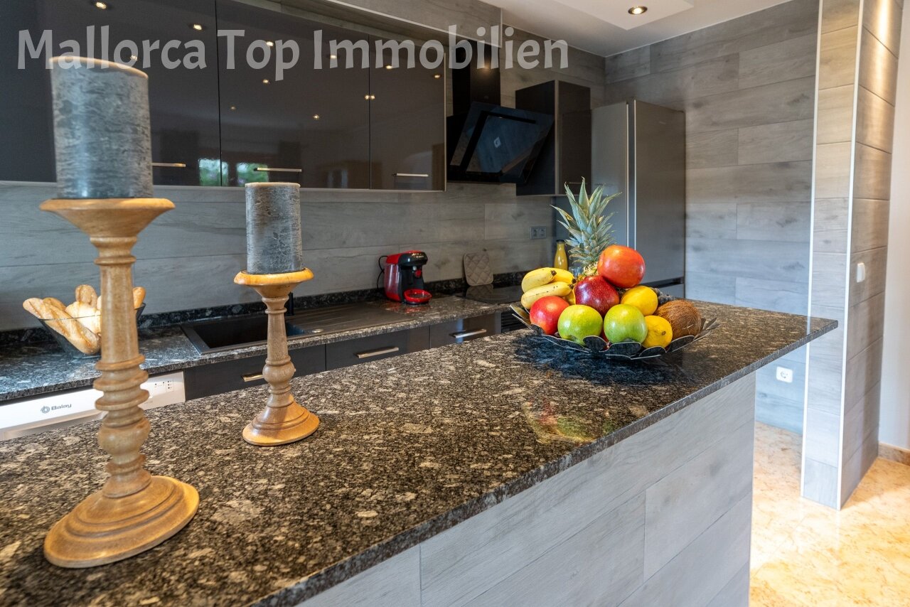 Moderne Küche mit edler Granit-Arbeitsplatte und integrierter Kochinsel Moderne Küche mit edler Granit-Arbeitsplatte und integrierter Kochinsel