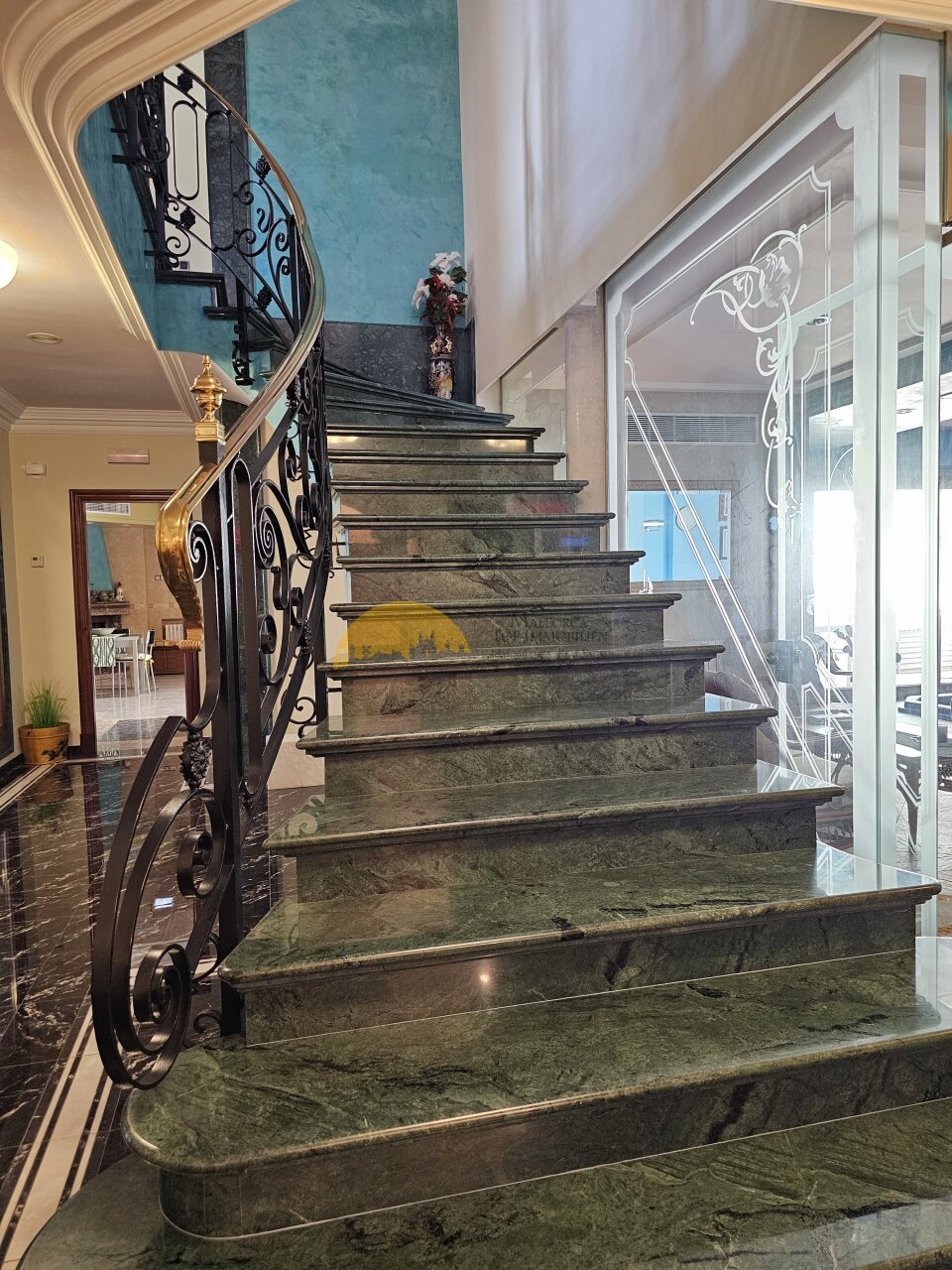 Edle Marmortreppe mit kunstvollem Schmiedeeisen-Geländer und eleganter Raumhöhe – Verbindung zwischen den Ebenen als architektonisches Highlight Edle Marmortreppe mit kunstvollem Schmiedeeisen-Geländer und eleganter Raumhöhe – Verbindung zwischen den Ebenen als architektonisches Highlight