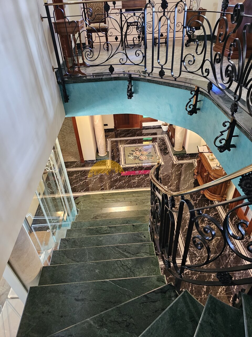 Repräsentative Marmortreppe mit kunstvollem Schmiedeeisen-Geländer und offener Raumhöhe – Verbindung zwischen den Ebenen als architektonisches Highlight Repräsentative Marmortreppe mit kunstvollem Schmiedeeisen-Geländer und offener Raumhöhe – Verbindung zwischen den Ebenen als architektonisches Highlight