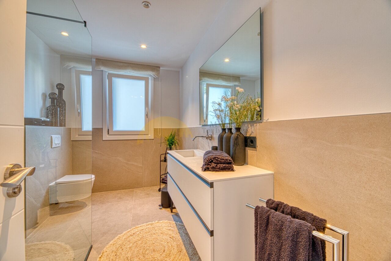 Luxuriöses Badezimmer mit begehbarer Dusche, Doppelwaschtisch und großformatiger Spiegelfront Luxuriöses Badezimmer mit begehbarer Dusche, Doppelwaschtisch und großformatiger Spiegelfront