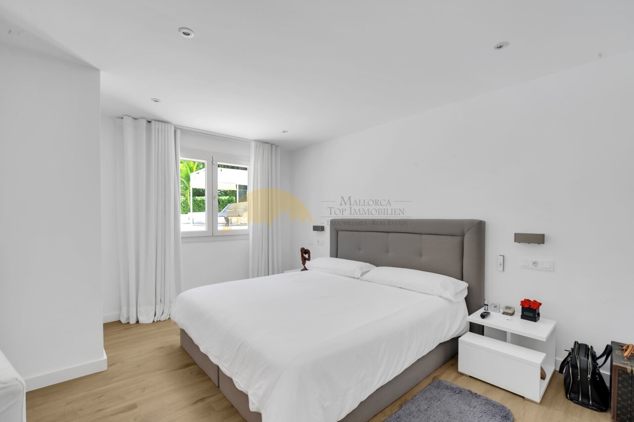 Helles Schlafzimmer mit großflächigen Fenstern und direktem Terrassenzugang