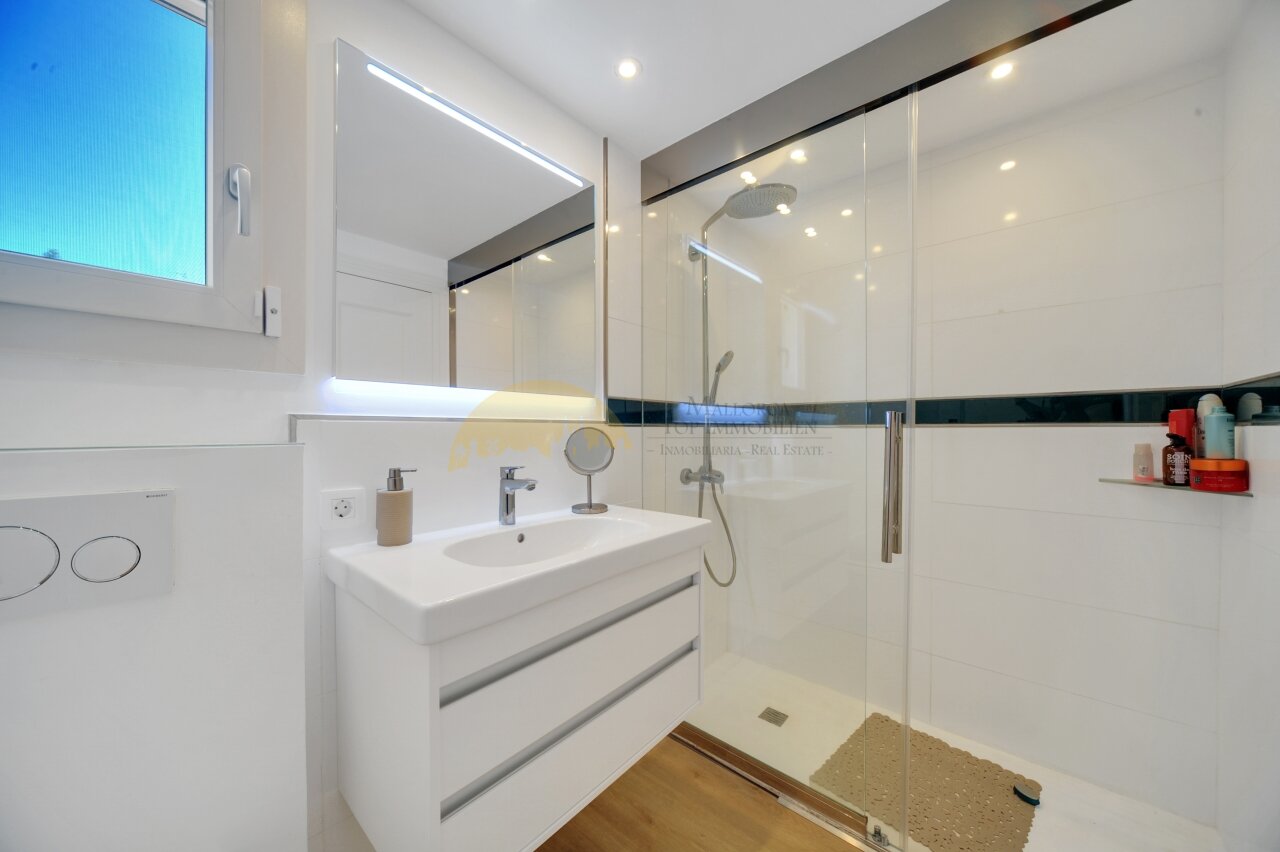 Modernes Badezimmer mit begehbarer Dusche und hochwertiger Spiegelbeleuchtung