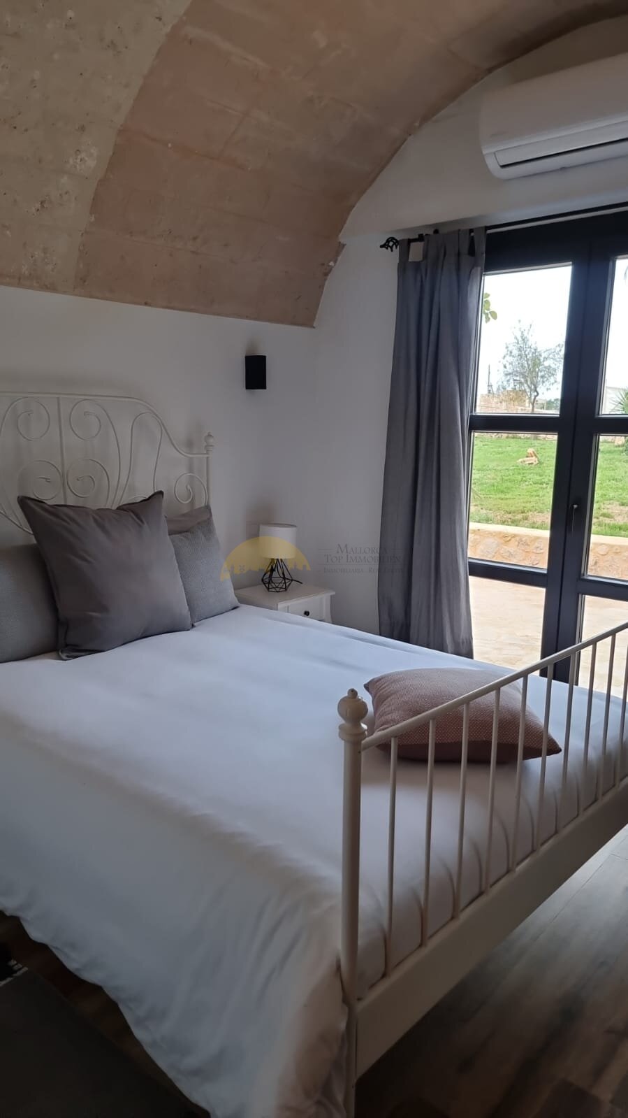 Helles Schlafzimmer mit Spitzbogenfenster und Klimaanlage Helles Schlafzimmer mit Spitzbogenfenster und Klimaanlage