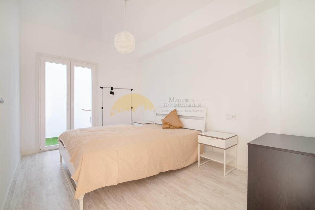 Helles Schlafzimmer mit raumhohen Glastüren und direktem Außenbereich