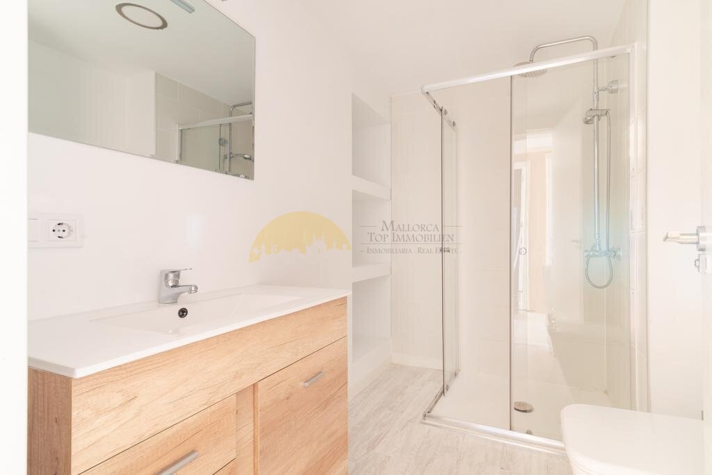 Modernes Badezimmer mit ebenerdiger Dusche und hochwertigem Spiegelschrank