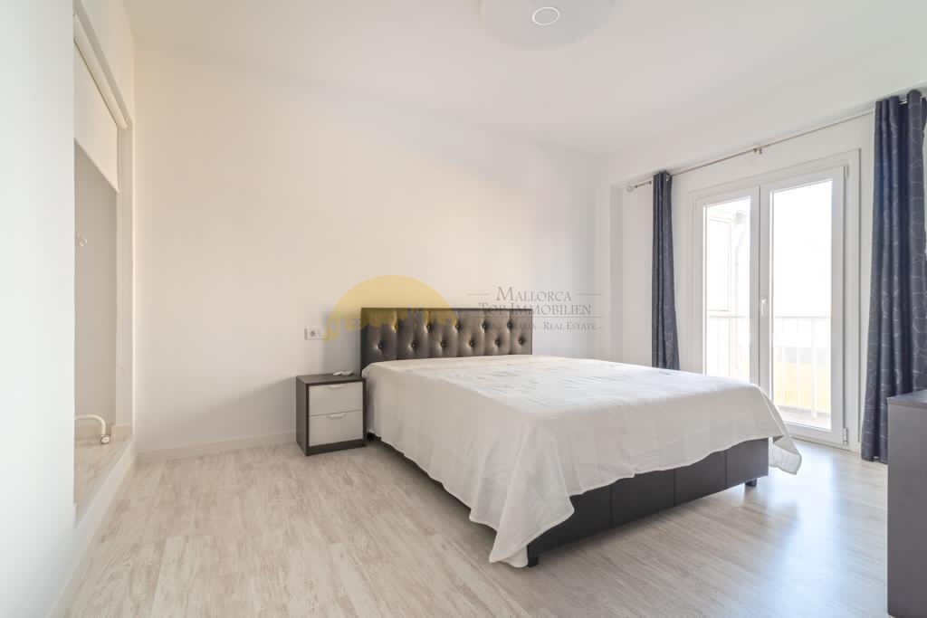 Helles Schlafzimmer mit großflächigen Glastüren und Zugang zur Terrasse