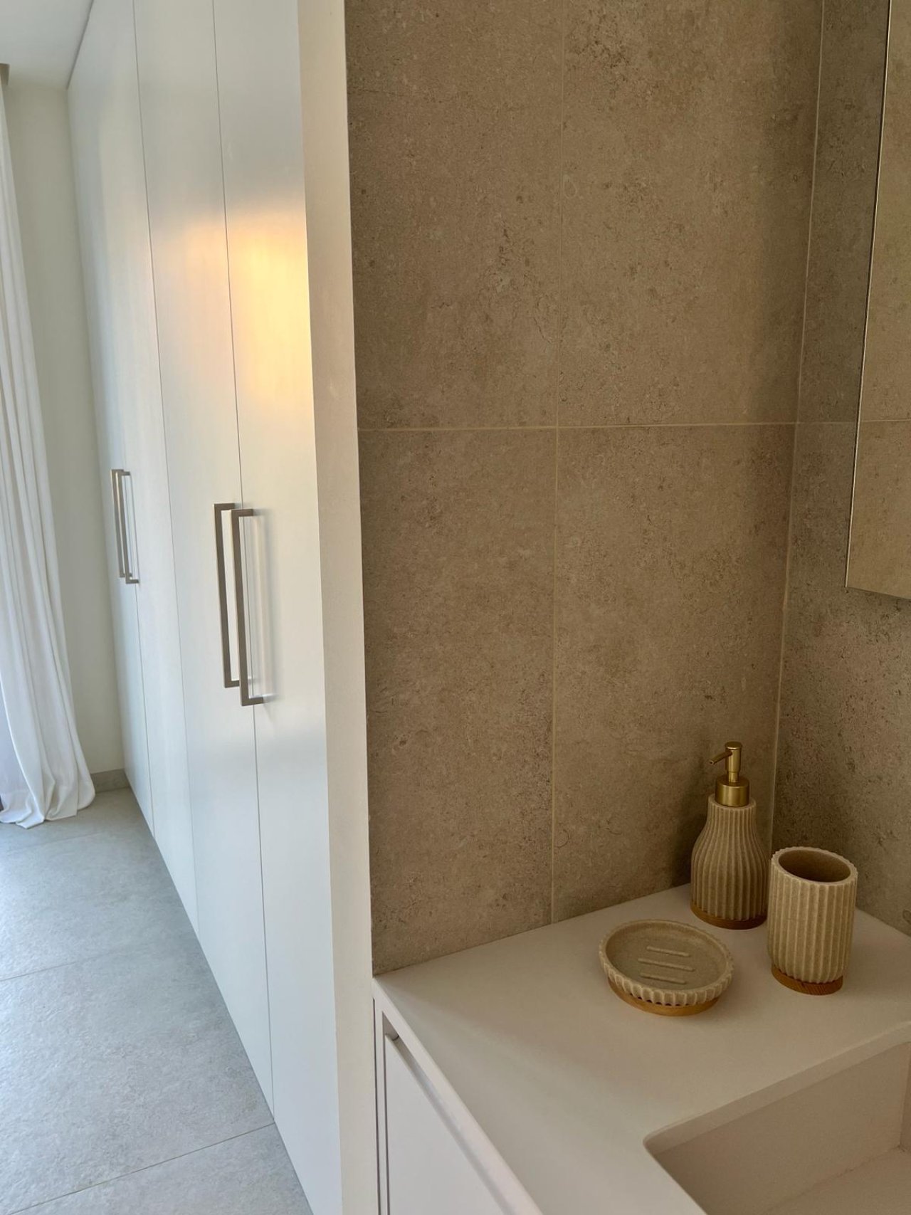 Modernes Badezimmer mit ebenerdiger Dusche, Natursteinwänden und praktischer Waschtischzone Modernes Badezimmer mit ebenerdiger Dusche, Natursteinwänden und praktischer Waschtischzone